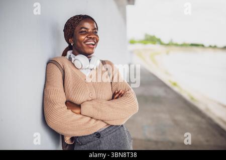 Portrait of young happy black woman with dental braces. She is looking away and smiling. Stock Photo