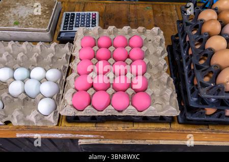 Market display with three trays of eggs, one with white eggs, one with pink eggs, and one with brown eggs. Hua Hin street market, Thailand Stock Photo