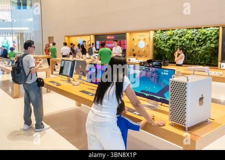 People are browsing Apple iMac Pro computers electronics in a brightly lit Apple store. Iconsiam mall, Bangkok Thailand Stock Photo