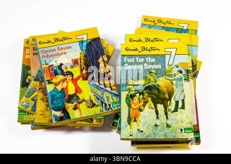 A collection of Enid Blyton's Secret Seven books stacked with colorful covers depicting scenes from children's adventures Stock Photo