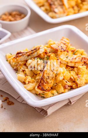German egg dumplings with bacon, fried onions and grilled Halloumi cheese Stock Photo