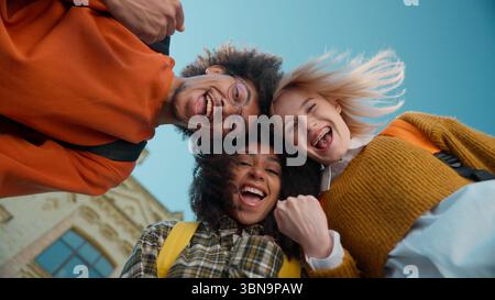 Bottom views three multiracial students together in city university leaning heads African American man male guy Caucasian women girls females Stock Photo