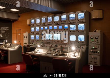 Control Room With Multiple Monitors Displaying Surveillance Feeds in a Retro Setting Stock Photo