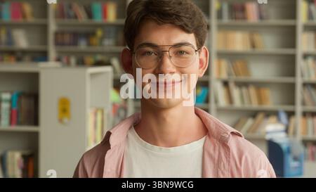 Portrait smiling happy positive Caucasian teen boy student guy male pupil man teenager in glasses looking smile at camera studying learning in school Stock Photo