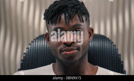 Close up portrait African American ethnic man male guy serious mood unsmiling confident emotion headset in futuristic studio futurism room looking at Stock Photo