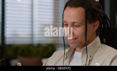 Ethnic guy business man male businessman with laptop using smartphone technology global connections communication in office chatting social media Stock Photo