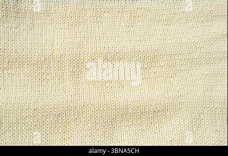 A detailed macro shot shows the milky fabric. The stockinette stitch with neat vertical V-shaped patterns creates a soft, smooth and textured surface. Stock Photo