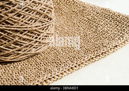 Skein of ECO raffia on a knitted surface. Palm leaf for knitting bags and various beach accessories. Stock Photo