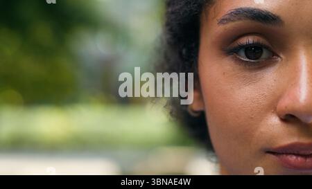 Portrait half face cropped view African American ethnic business woman looking at camera calm serious dark skin businesswoman look health medicine Stock Photo