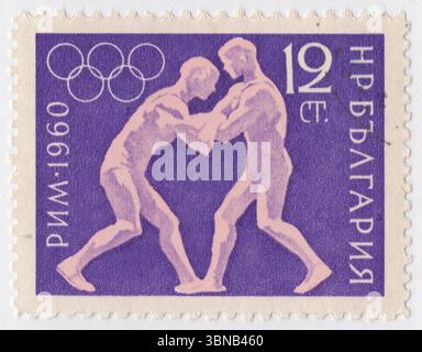 BULGARIA — 1960 August 29: 12 stotinki violet and pink postage stamp depicting Wrestling. 17th Olympic Games, Rome, 25 August — 11 September. The Bulgarian Olympic Committee was created in 1923 and first sent a team to the Summer Olympic Games in 1924. The nation has participated in every Summer Games since then, except for 1932 (during the Great Depression), 1948 (Bulgaria's role in World War II) and 1984 (part of the Soviet-led boycott of the 1984 Summer Olympics). Bulgaria first participated in the Winter Olympic Games in 1936 and has attended every Winter Games since then Stock Photo