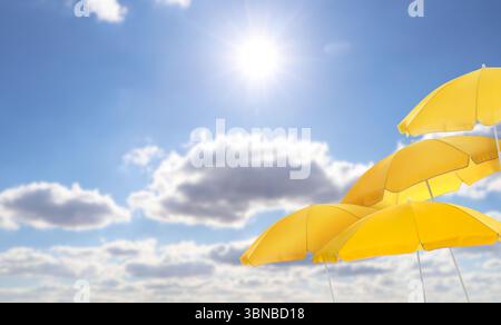 Yellow beach umbrellas against blue sky on sunny day Stock Photo