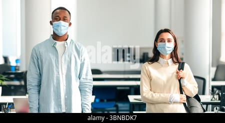Portrait of international students wearing protective medical masks Stock Photo