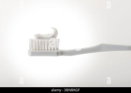 White toothbrush with toothpaste, white background, USA Stock Photo