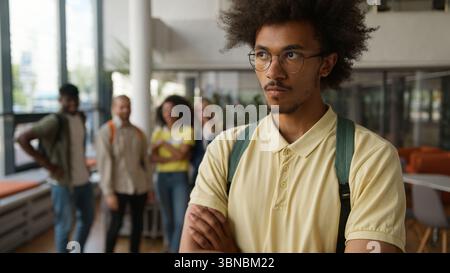 African American man guy male student suffering offended sad with mockery laughing pointing fingers envy classmates students discrimination bullying Stock Photo