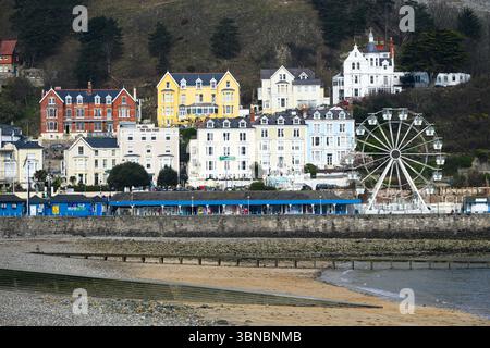 Llandudno, Wales, UK - March 20, 2025; Llandudno ferris wheel and traditional seaside property above beach Stock Photo