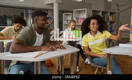 Four multiracial students studying learning education together in classroom high school university college writing in copybook lesson African man guy Stock Photo