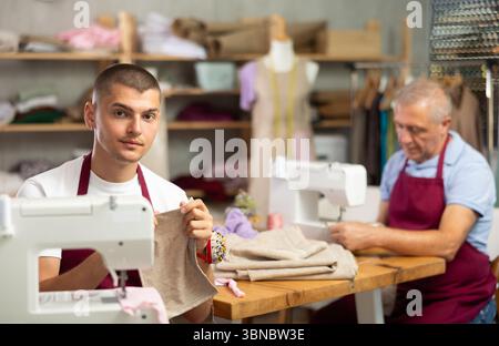 Two male tailors working with fabric Stock Photo