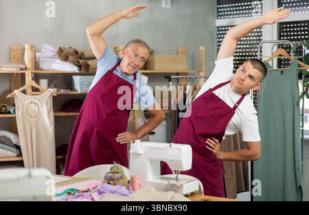 Male tailors doing a warm-up at work Stock Photo