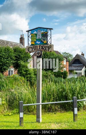 Typical wooden painted name board in Childrey a village in the Vale of White Horse near Wantage, Oxfordshire, UK Stock Photo
