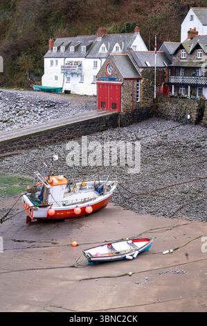 Low tide and boats at anchor on the sea shore at famous harbour village of Clovelly on the Bristol Channel near Bideford in Devon Stock Photo