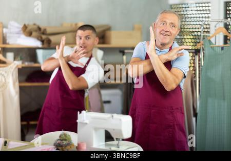 Male tailors doing a warm-up at work Stock Photo