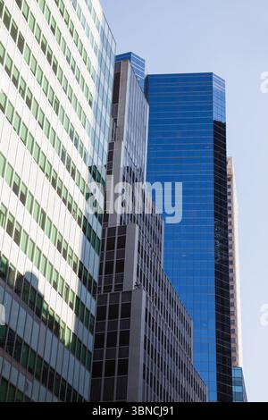 Three high-rise office towers are rising in flat design, showing concrete beams and glass panels Stock Photo