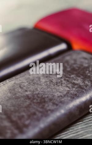Showcasing a trio of premium leather wallets in black, brown, and red, perfect for enhancing your everyday style and practicality Stock Photo