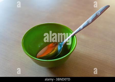 Empty bowl with spoon on top of it. The bowl is empty and the spoon are silver Stock Photo