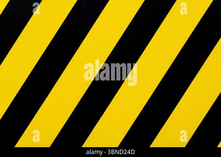 Yellow and black striped sign with a black stripe on the left and a yellow stripe on the right Stock Photo