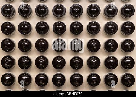 old vintage lamp switch. Black retro classic light bulb switch electric connection device on off. power switch lever on white wall surface texture. lo Stock Photo