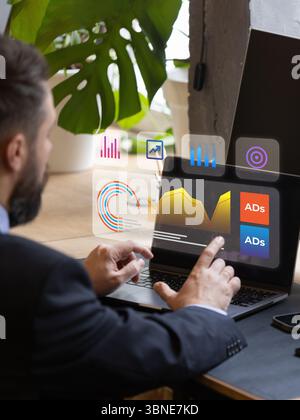 Executive managing digital advertising metrics using futuristic holographic laptop interface Stock Photo