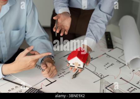 Housing Project Discussion and Planning. Professionals engaged in collaborative housing design evaluation. Stock Photo