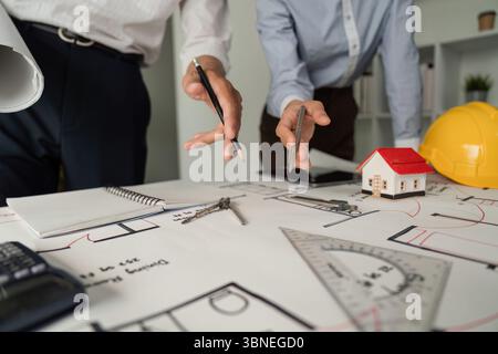Architectural Planning and Drawing. Close-up of a team discussing blueprints and designs at a work table. Stock Photo