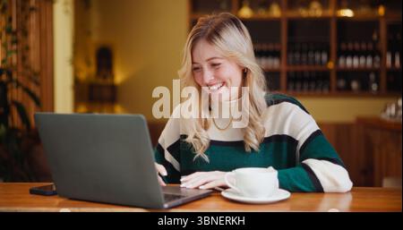 Student, laptop and woman in restaurant, smile and research for university project, internet and email. Happy, PC and person in cafe, connection and Stock Photo