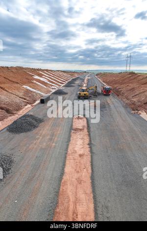 Wheel loader unloading gravel on a highway under construction in Czechia Stock Photo
