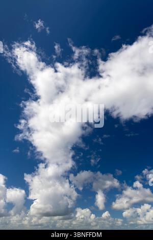 White clouds float across a vibrant blue sky Stock Photo