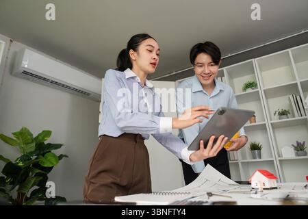 Digital Collaboration and Presentation. Team members sharing ideas using a tablet in a modern workspace. Stock Photo