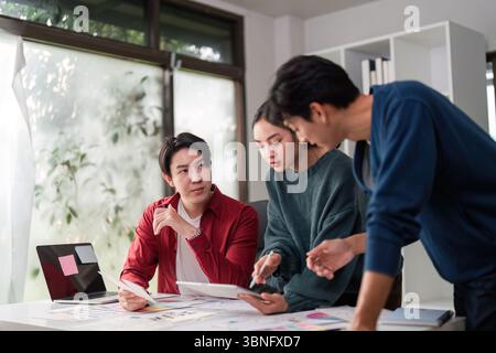 Brainstorming and UIUX Design. A creative team collaborates on user interface ideas and design concepts in a modern workspace. Stock Photo