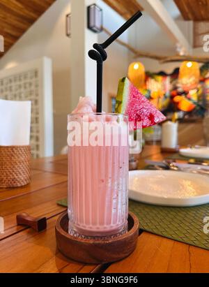 Banana strawberry smoothie in a clear wavy glass. Stock Photo