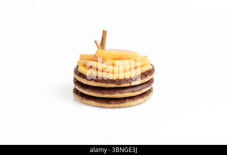 Three chocolate biscuits topped with sliced papaya decorated with cinnamon sticks Stock Photo