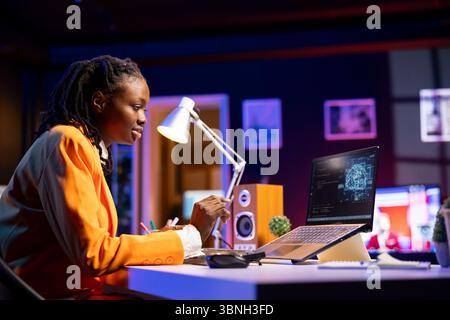 Developer writing code on laptop and doing maintenance on artificial intelligence neural networks computerized model. Tech support expert typing on keyboard, doing checkup on AI systems in home office Stock Photo