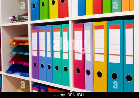 Colorful folders on a shelf in a modern office space. Busssines Stock Photo