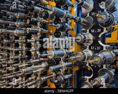 Various cutting tools and holders in the magazine of a CNC milling machine. Metalwork, precision engineering and machine shop industrial background Stock Photo