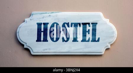 HOSTEL text marble sign on grey brown wall Stock Photo