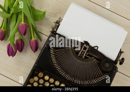 Typewriter and flowers on table Stock Photo