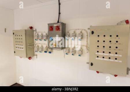 Flat design is showing three wall-mounted control panels on white wall with power outlets and wires Stock Photo