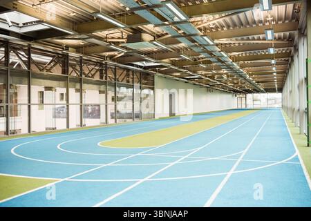 Multi-lane running track is curving inside flat design sports hall with glass partition wall Stock Photo