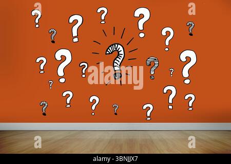 Question marks on orange wall Stock Photo