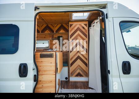 Step inside a stylish camper featuring a cozy, wooden interior designed for travel and teleworking. Perfect balance of comfort and mobility for digita Stock Photo