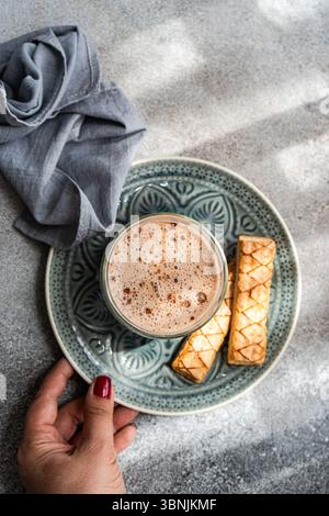 A delightful puff pastry filled with sweet apricot jam served alongside a freshly brewed cup of rich cocoa, creating a perfect indulgent snack experie Stock Photo